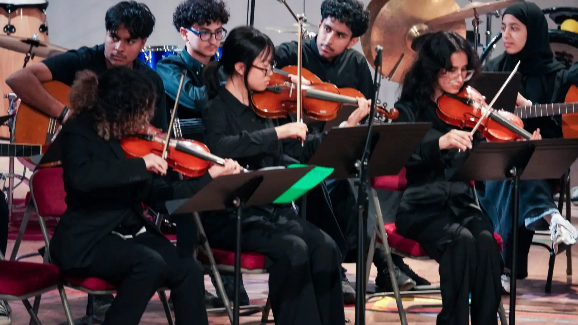 AISJ string students playing violins in a school ensemble