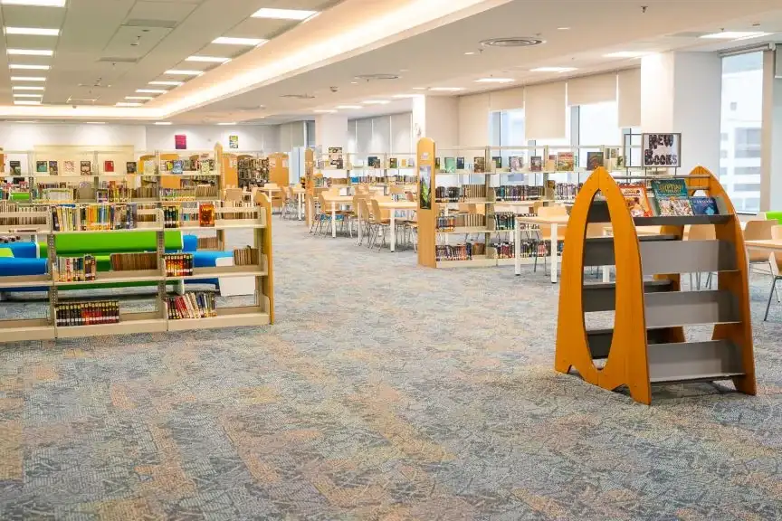 AISJ library and learning commons with bookshelves, soft seating, and study tables