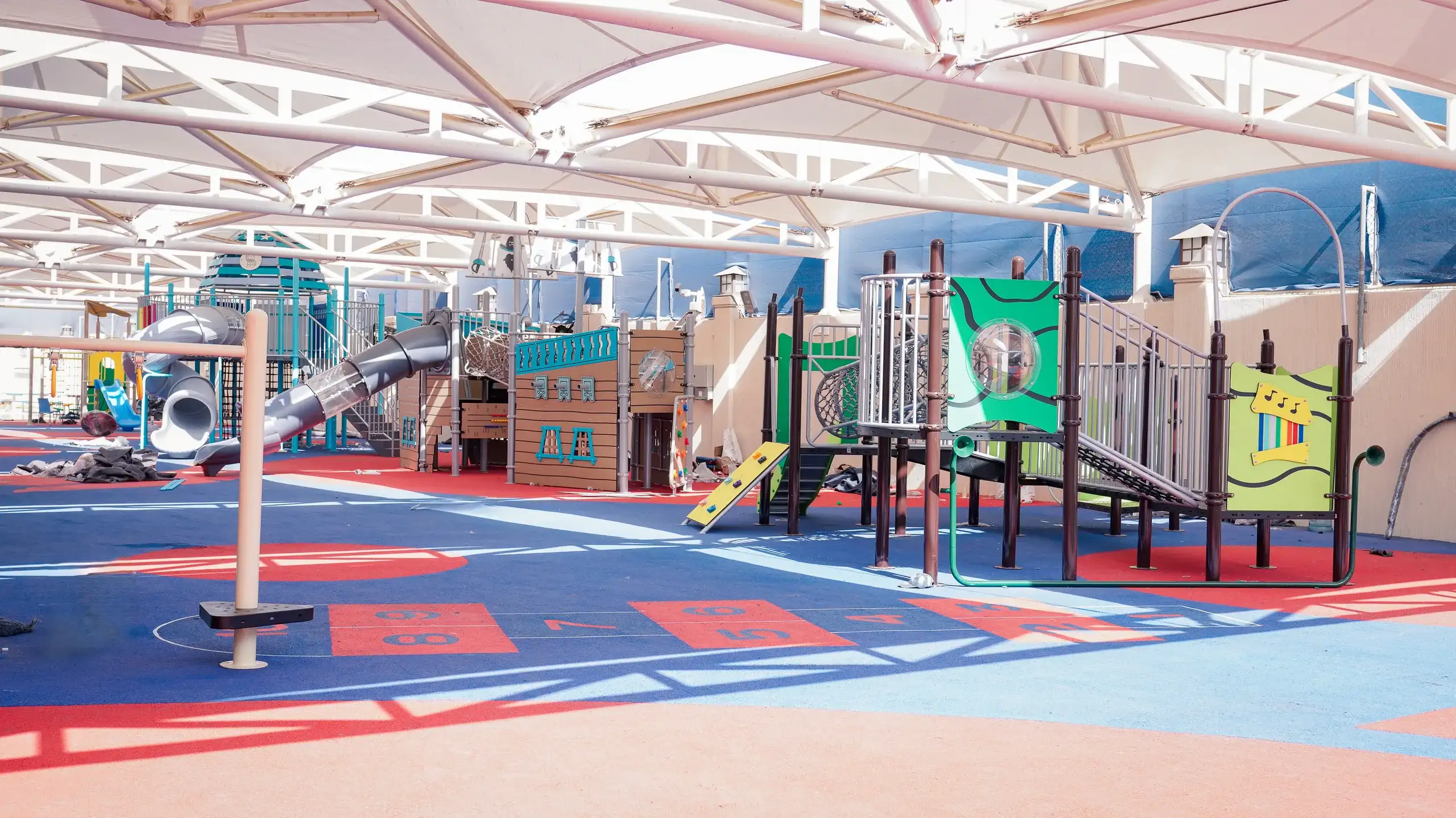 Covered outdoor play area with climbing structures on the AISJ campus