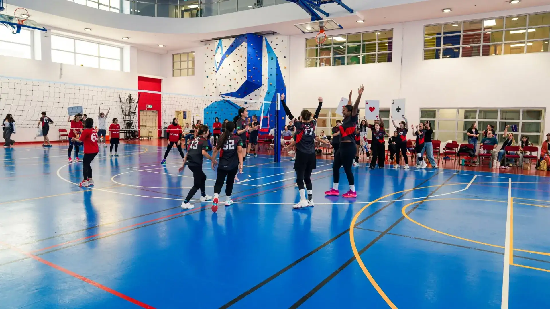 Student-athletes competing on the court in the AISJ gymnasium