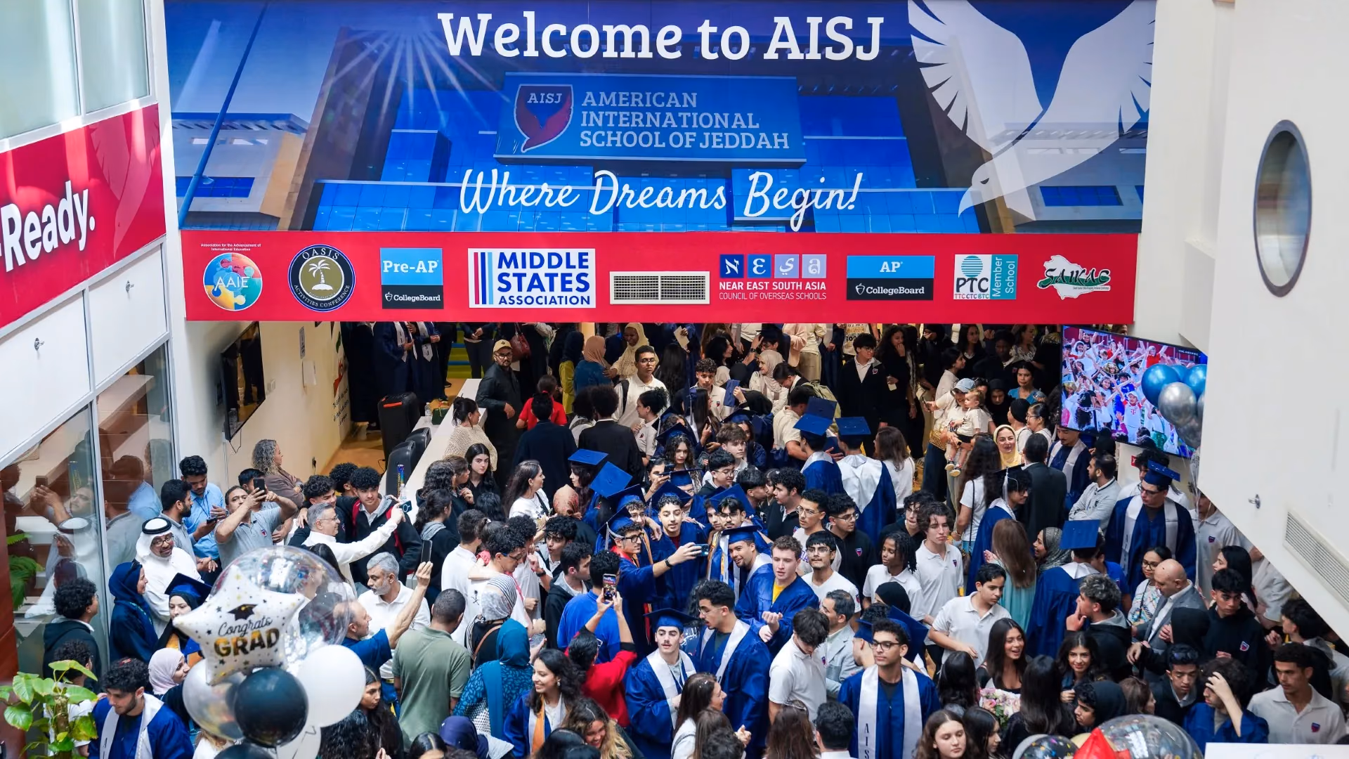AISJ students gathered under the welcome banner during a school assembly