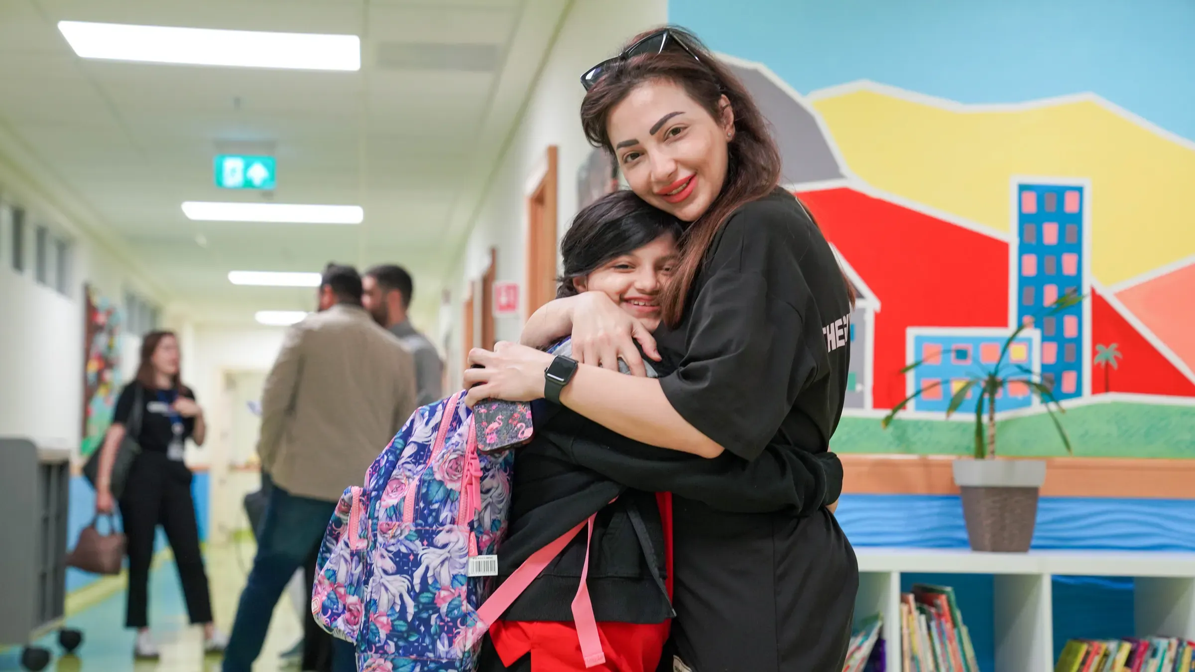 A staff member welcoming a student on the first day of school