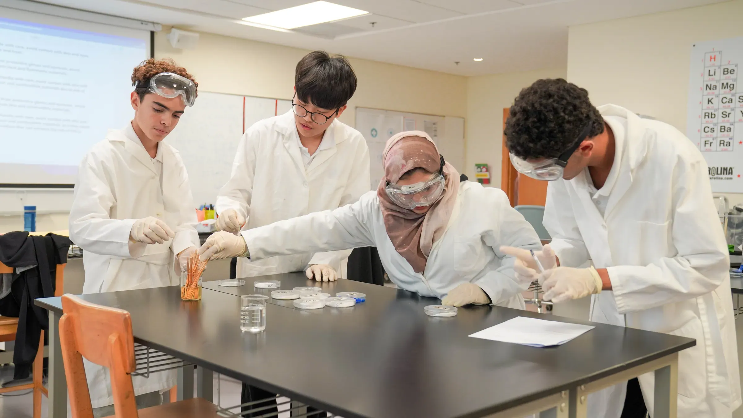 High school students in lab coats running a flame test